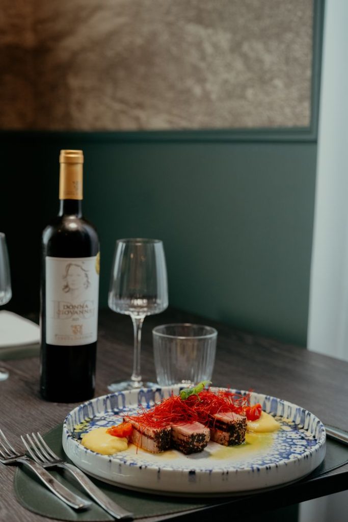 A delicious gourmet meal served with red wine at a cozy restaurant in Calabria, Italy.