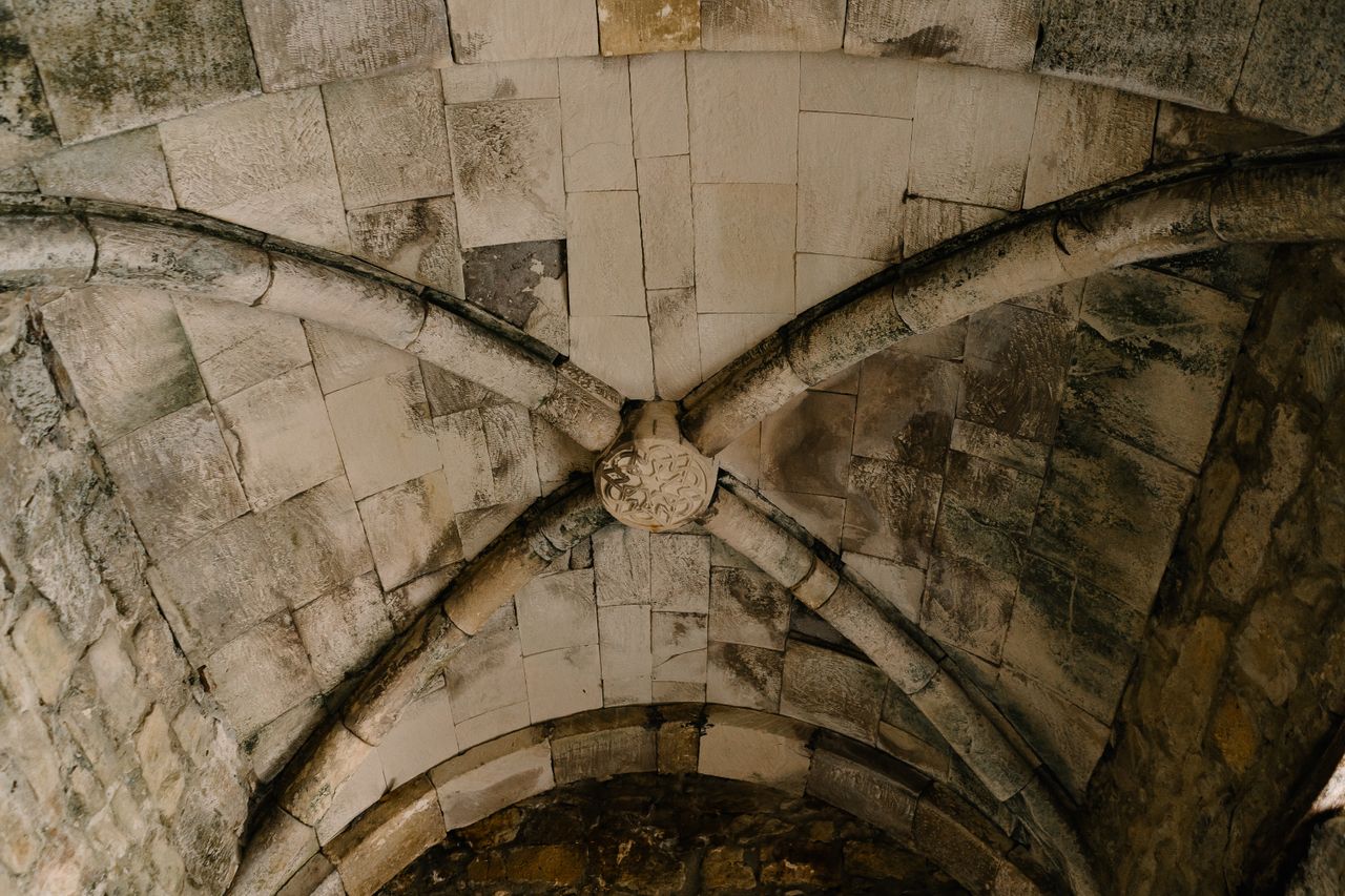 Detailed view of a gothic stone vaulted ceiling with intricate cross-rib structure.